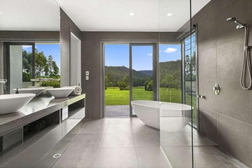 a bathroom with two sinks and a tub and a shower at Serendipity, Kangaroo Valley in Barrengarry
