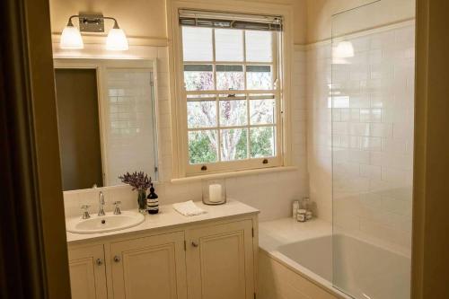 a bathroom with a sink and a tub and a window at Somerset, Berrima, Southern Highlands in Berrima