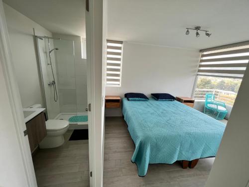 a bedroom with a bed and a bathroom with a shower at Departamento Reñaca alto in Viña del Mar