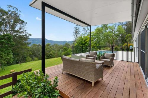 a patio with a couch and chairs on a deck at Paddington, Kangaroo Valley in Barrengarry