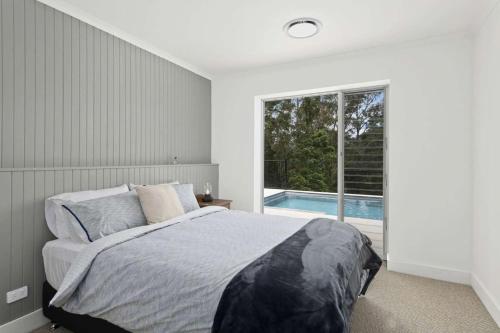 a bedroom with a bed and a swimming pool at Paddington, Kangaroo Valley in Barrengarry