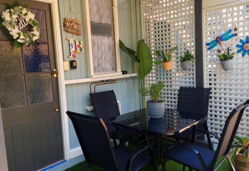 JDs Tropical stays في كيرنز: فناء مع طاولة وكراسي وباب