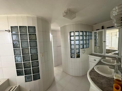 La salle de bains blanche est pourvue d'un lavabo et d'un miroir. dans l'établissement Casa Marrakech VIP, à El Agua