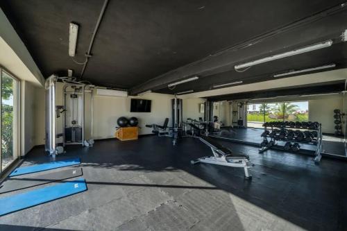 einen Fitnessraum mit Kardiogeräten und einem großen Fenster in der Unterkunft Lumina at Vista Velas II Los Cabos in El Pueblito