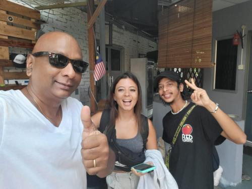 two men and a woman giving a thumbs up at Langkawi-Village Mix Dormitory in Pantai Cenang