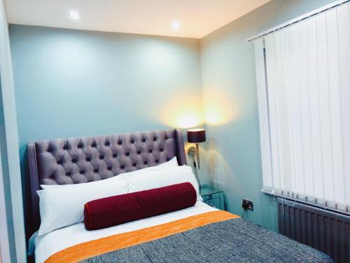 ein Schlafzimmer mit einem Bett mit einem roten Kissen darauf in der Unterkunft Manchester City home with parking in Manchester