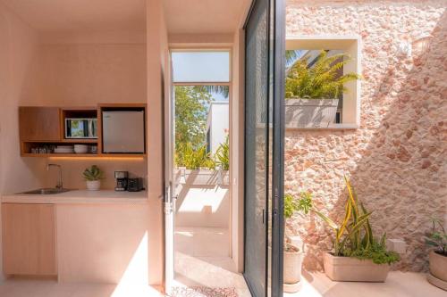een keuken met een glazen schuifdeur naar een patio bij Kinal 04 - Apartment in Mérida
