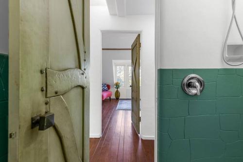 a bathroom with a shower with green tiles and a door at The Magic Castle Unit 1 -Six Flags Universal LAX in Santa Clarita