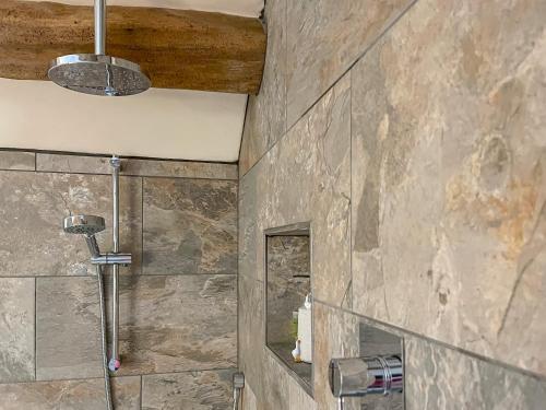 a bathroom with a stone wall with a shower at Little Pythorn - Uk45253 in Westerdale