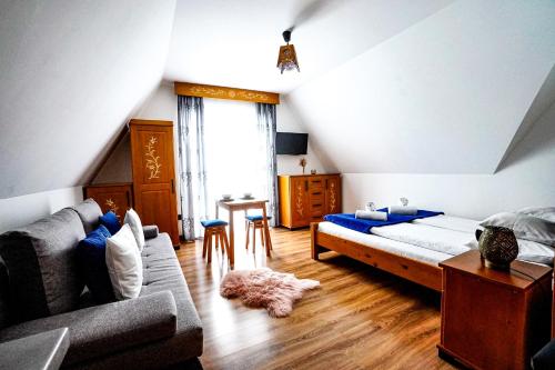 een slaapkamer met een bed, een bank en een tafel bij Apartamenty u Trebuniów in Suche