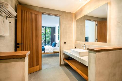 bagno con lavandino e specchio di Seaside Escape 4br Villa, 190m To Canggu Beach a Canggu