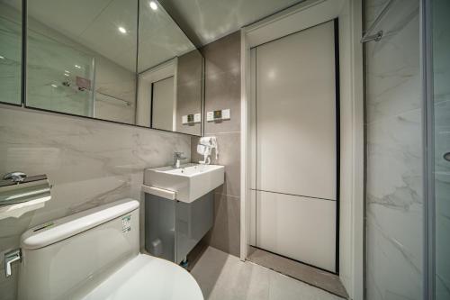 a bathroom with a toilet and a sink and a shower at BORUISI Executive Apartment in Shenzhen
