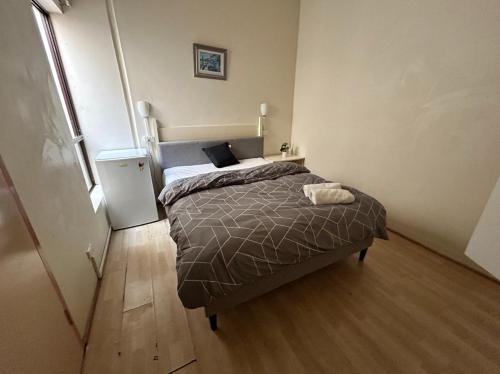 a small bedroom with a bed and a refrigerator at Studio 26 - Wright Lodge in Adelaide