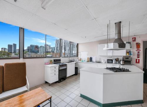 een keuken met witte apparatuur en uitzicht op de stad bij Studio 26 - Wright Lodge in Adelaide