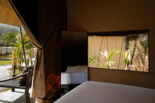 a bedroom with a bed and a window at Toteme Glamping and Hot Spring Kintamani in Kintamani