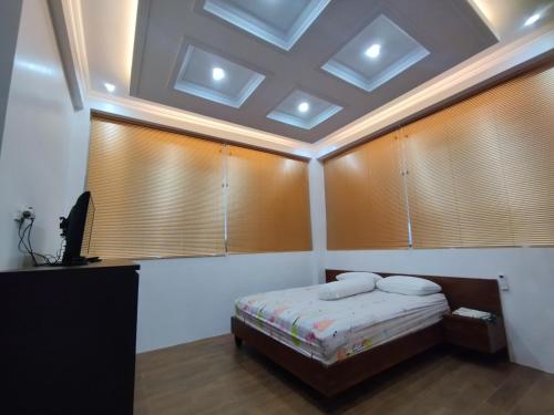 a bedroom with a bed in a room with windows at Saira Hotel dan Homestay Syariah in Sleman