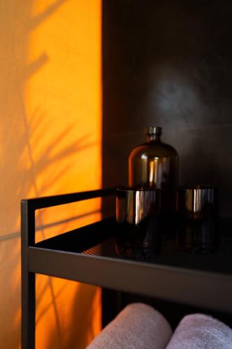 a bottle on a table with two cups on it at Toteme Glamping and Hot Spring Kintamani in Kintamani