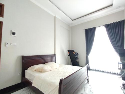 a bedroom with a bed and a large window at Saira Hotel dan Homestay Syariah in Sleman