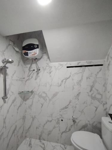 a white bathroom with a toilet and a sink at Saira Hotel dan Homestay Syariah in Sleman