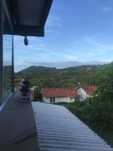 een stenen loopbrug met uitzicht op een huis bij Paikea Hostel Praia do Rosa in Praia do Rosa