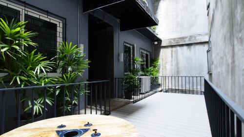 a wooden table on a balcony with plants at Sribumpen Plus in Bangkok