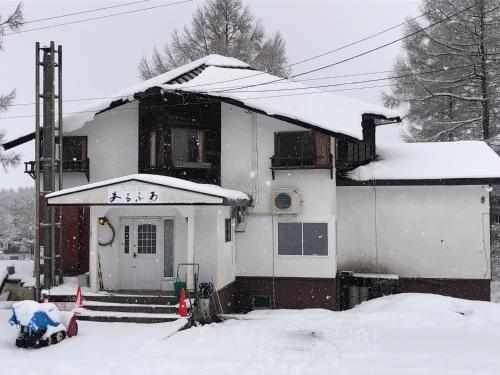 a house is covered in snow at Alpha Live Madarao in Madarao Kogen