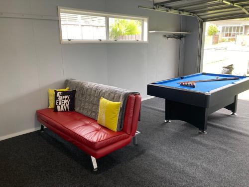 a room with a couch and a pool table at Family Adventure Get Away in Rotorua