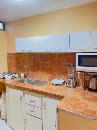 a kitchen with white cabinets and a counter top at Moonlight, Galápagos in San Cristobal