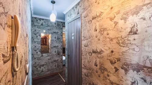 um corredor com uma parede com desenhos em 1-комнатная квартира Виктория посуточно в центре города Петропавловска рядом с ТРЦ пожить em Petropavl