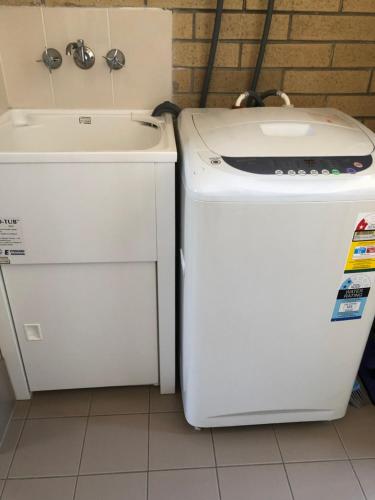 a washer and dryer next to a sink at Unit 4 Pattison in Emu Park