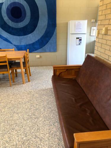 a couch in a room with a table and a refrigerator at Unit 3 Pattison in Emu Park