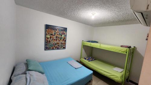 a small room with a bed and a shelf at Apartasol Santa Fe de Antioquia - Ciudadela Santa Fe in Santa Fe de Antioquia