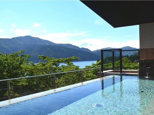 a swimming pool with a view of a lake and mountains at Ryuguden in Hakone