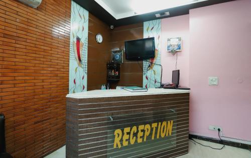eine Rezeption mit einem TV an einer Backsteinwand in der Unterkunft Hotel J P Inn Near Patel Nagar Metro Station in Neu-Delhi
