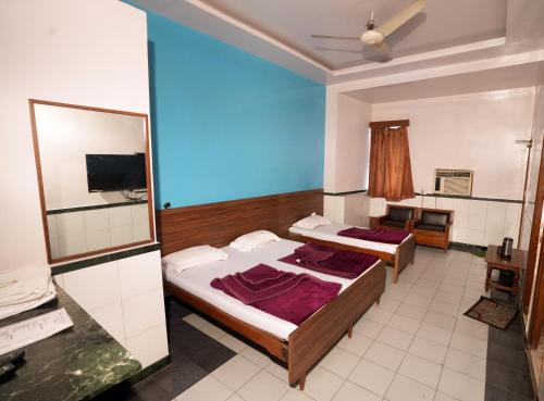 1 dormitorio con 2 camas y espejo en New Royal Hotel, en Nueva Delhi
