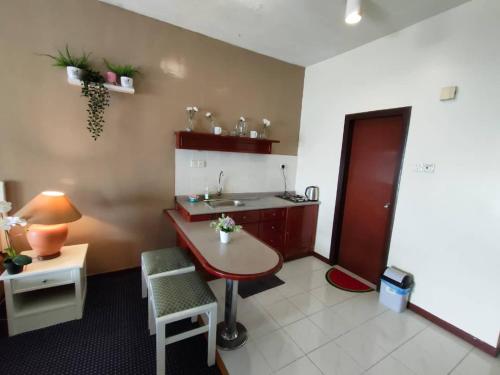 a kitchen with a sink and a table and a desk at Seaview Deluxe Studio couples room S in Tanjung Bungah