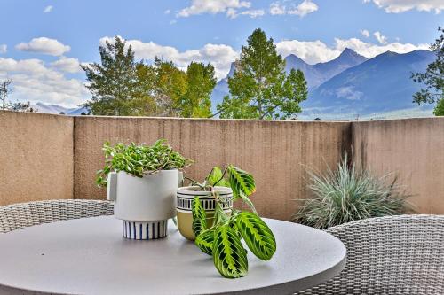 una mesa con dos jarrones y plantas en un patio en Ravens Crest Lodge - Stunning Views Perfectly Located on Main Street, en Canmore