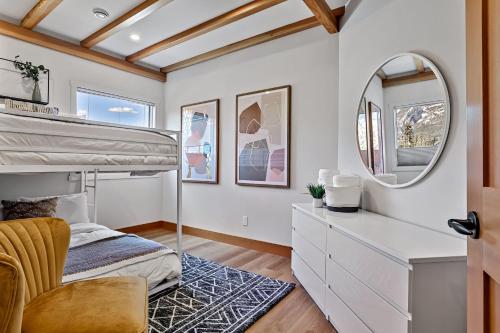 a bedroom with a bunk bed and a mirror at Ravens Crest Lodge - Stunning Views Perfectly Located on Main Street in Canmore