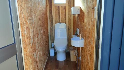 a small bathroom with a toilet and a sink at 里山グランピングむすびペット棟 in Mizunami