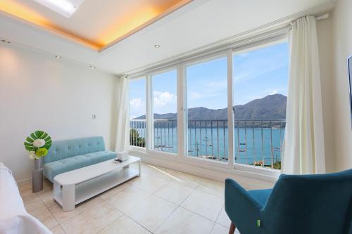 a living room with a view of the ocean at Melodia Pension in Geoje 