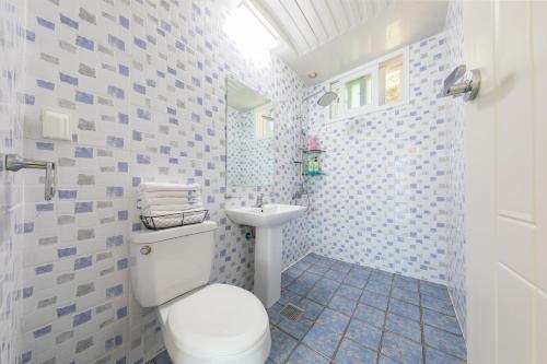 łazienka z toaletą i umywalką w obiekcie Melodia Pension w mieście Geoje