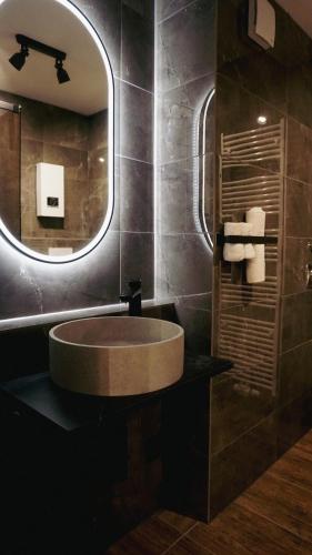een badkamer met een ronde wastafel en een spiegel bij Atrium Apartments Aachen in Aken