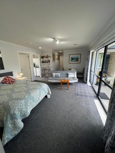 a bedroom with a bed and a living room at Taipa Views Bed & Breakfast in Kaitaia