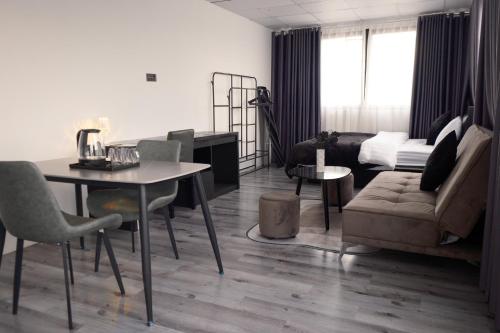 uma sala de estar com uma mesa e um sofá em Atlantis Motel & Apartment em Hanói