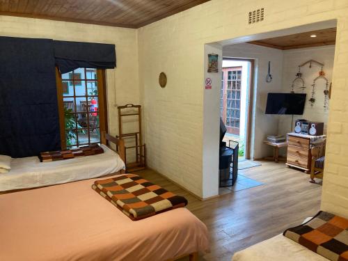 1 dormitorio con 2 camas y 1 habitación con escritorio en Haus Barbara Guest House en Bredasdorp