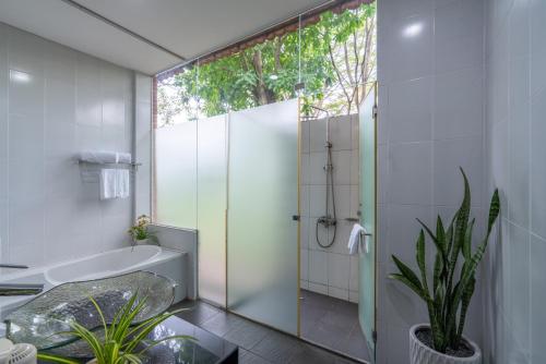 a bathroom with a shower and a tub and a sink at Mekong Long Thanh Resort & Reststop in Ấp Thanh Nguyên