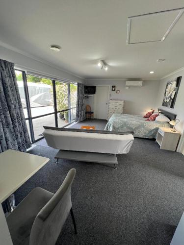 a bedroom with a bed and a large tub in it at Taipa Views Bed & Breakfast in Kaitaia