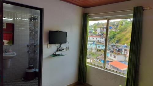 a bathroom with a window with a view of a city at Achus Holidays in Munnar