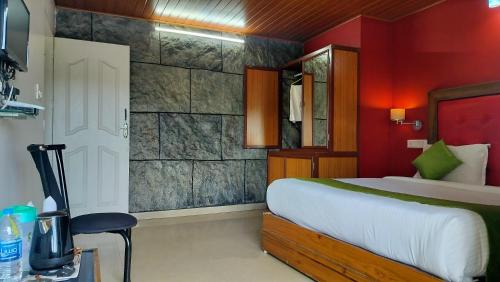 - une chambre avec un lit et un mur rouge dans l'établissement Achus Holidays, à Munnar