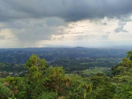 een uitzicht op een vallei met een regenboog in de lucht bij Cabaña Bella Vista in Pereira